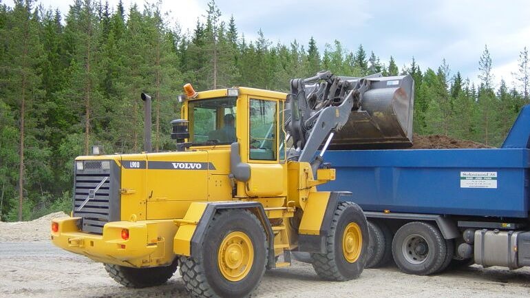 Hjullaster som laster masser på lastebil